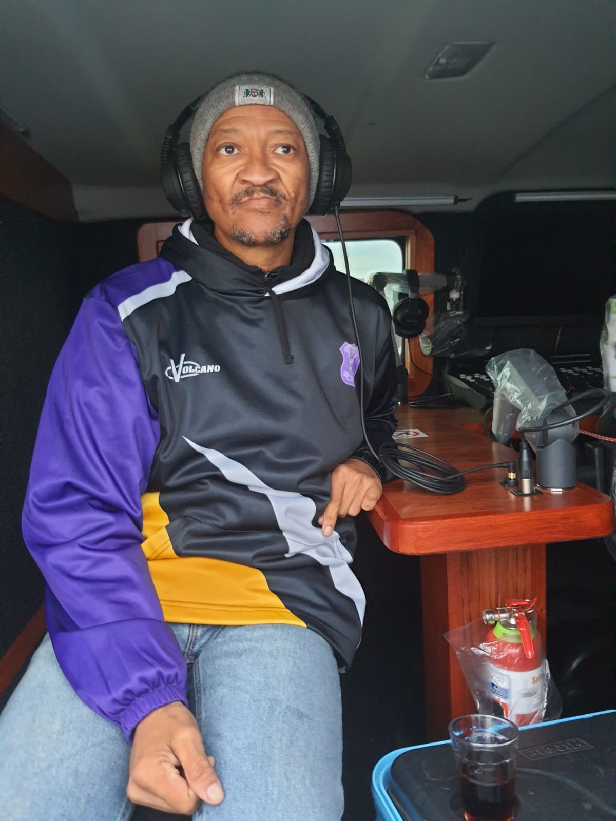 Presenter on air inside the Kouga FM mobile broadcast studio